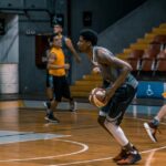 Young athletes engage in a dynamic basketball practice indoors, focused on skill development.